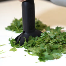 Load image into Gallery viewer, dbChopper in use chopping fresh herbs like cilantro and parsley on a clean counter