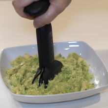 Load image into Gallery viewer, dbChopper mashing fresh avocados for dip in a white ceramic dish

